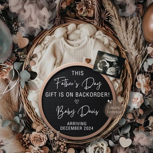 Könnte beinhalten: Ein schwarzes Buchstabenbrett mit weißem Text, der "THIS Father's Day GIFT IS ON BACKORDER! Baby Davis ARRIVING DECEMBER 2024" lautet. Das Buchstabenbrett ist von einem Weidenkorb umgeben, der mit braunem und weißem Stoff, einem weißen Strampler, einem kleinen Ultraschallbild und getrockneten Blumen gefüllt ist.