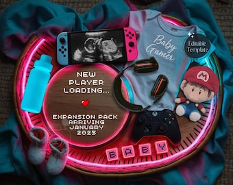 Op de afbeelding: Een roze en blauwe Nintendo Switch-console met een zwart-witte echografie op het scherm. Een blauwe waterfles, een zwarte gaming-headset, een zwarte Xbox-controller en een pluche Mario-figuur zijn ook op de afbeelding te zien. De achtergrond is een lichtblauwe en turquoise stof. De tekst "Baby Gamer" staat op een lichtblauwe romper. De tekst "New Player Loading... Expansion Pack Arriving January 2025" staat op een roze neon-bord. De tekst "Baby" staat op roze neon-blokken.
