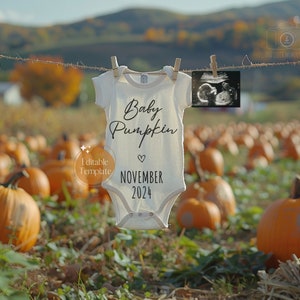 Pode incluir: Um macacão branco com o texto "Baby Pumpkin" e "Novembro 2024" pendurado em um varal em um campo de abóboras.