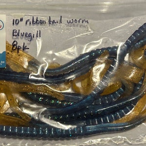 May include: A bag of 10-inch bluegill ribbon tail worms. The worms are a mix of blue and gold colors with glitter.