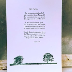 May include: A black and white print of a poem titled "The Trees" by Philip Larkin. The poem is about the cyclical nature of trees and how they seem to die and be reborn each year. The print features two stylized trees at the bottom.