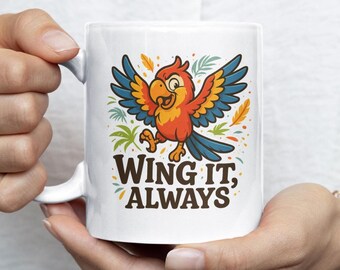May include: White ceramic mug featuring a colorful cartoon parrot with outstretched wings. The parrot is orange, red, yellow, and blue. The mug has the text "WING IT, ALWAYS" in brown letters.