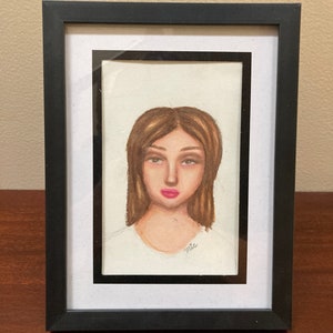Framed Colored Pencil Portrait Drawing Of A Woman With Pink Lips And Brown Eyes