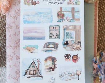 May include: A white sticker sheet titled Winter Weekend Getaways featuring various watercolor illustrations including a snowy landscape, a cozy cabin interior with a fireplace, a sleeping dog, mugs of hot cocoa, and a small A-frame house in the snow.