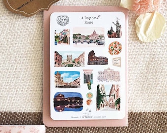Op de afbeelding: Een vel stickers met illustraties van verschillende bezienswaardigheden in Rome, Italië. De stickers zijn op een roze achtergrond en bevatten afbeeldingen van het Colosseum, de Trevi-fontein en het Pantheon. De tekst "A Day in Rome" staat bovenaan het vel gedrukt.