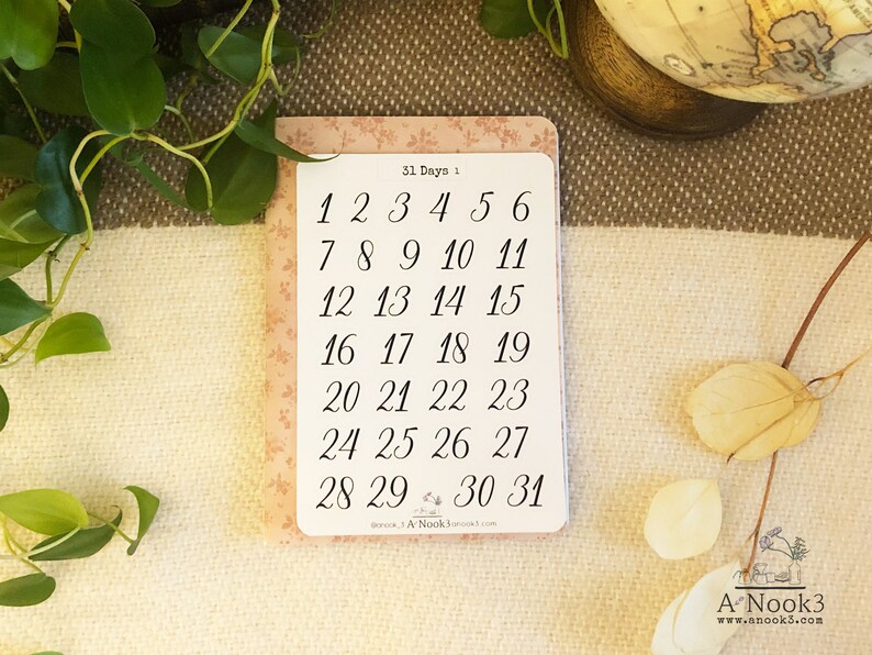 May include: A pink card with a floral pattern and the text "31 Days 1" printed on it. The card has a list of numbers from 1 to 31 in black ink.