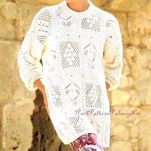 May include: Cream-colored, long-sleeved sweater with a round neckline and intricate openwork design. The sweater features a textured pattern with diamond and geometric shapes. The text "Past Pattern Palooza Co" is visible on the lower right side.