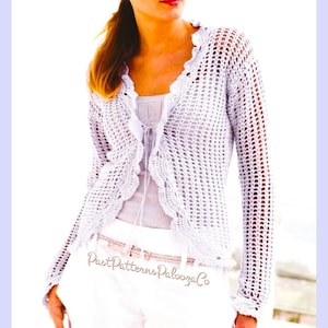 May include: A white, open-weave crochet cardigan with a scalloped edge. The long-sleeved garment has a delicate, airy design. The image also shows white pants and a light-colored top. The text "Past Patterns Palooza Co" is visible.