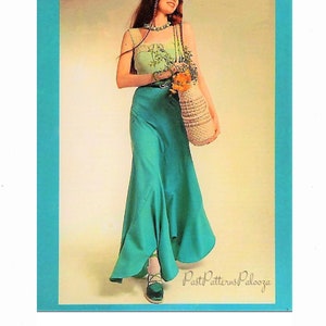 Puede incluir: Una mujer con un top estampado en verde y blanco, una falda maxi verde y un bolso de paja. Lleva un ramo de flores.