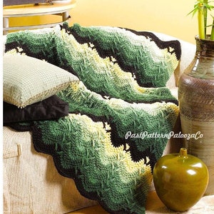 Peut inclure: Une couverture en crochet vert, jaune et noir avec un bord festonné est jetée sur un canapé. La couverture a un motif feuillu texturé. Le canapé est beige et a deux coussins. La couverture est sur un tapis beige. Le texte "PastPatternPaloozaCo" est visible dans le coin inférieur droit de l'image.