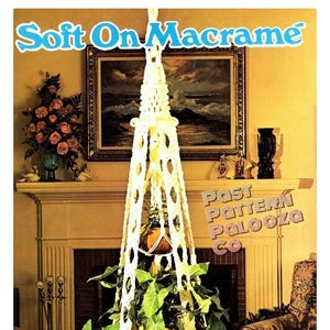 May include: A cream-colored macrame plant hanger featuring an intricate knotted design with a central vertical structure and a tassel at the bottom. The text Soft On Macrame and Past Pattern Palooza Co is printed on the image.