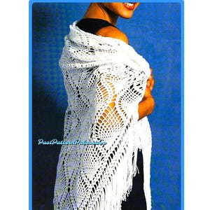 May include: White crochet shawl with a delicate openwork pattern and fringe. The shawl is draped over a person's shoulders.