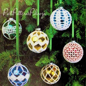 May include: Six crocheted Christmas ornaments hanging on a green Christmas tree. The ornaments are white, blue, red, and yellow. The ornaments are made with a lacy crochet pattern.