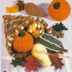 May include: Crocheted cornucopia filled with crocheted pumpkins, gourds, and leaves. The cornucopia is brown, green, and white. The pumpkins are orange. The gourds are yellow, green, and brown. The leaves are red, green, and brown.