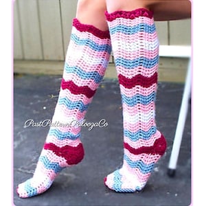 May include: Knee-high crochet socks in a chevron pattern. The socks feature alternating stripes of white, light blue, pink, and burgundy. The top and heel are burgundy. The text "Past Pattern Palooza Co" is visible.
