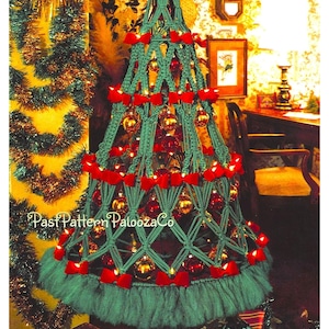 Puede incluir: Un árbol de Navidad de macramé verde decorado con lazos rojos, bolas doradas y rojas y luces blancas. El árbol está rodeado de regalos envueltos.