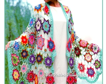 May include: A colorful, open-front crochet cardigan with a floral pattern. The cardigan features a light blue trim and is adorned with various colored flower motifs. The text "PastPatternPalooza Co" is visible on the garment.