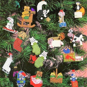 Peut inclure: Un sapin de Noël décoré d'ornements en feutre faits à la main. Les ornements présentent une variété d'animaux, dont un ours, un chat, une vache, un cochon et un pingouin. Les ornements sont tous de couleurs vives et ont un aspect artisanal et fantaisiste.