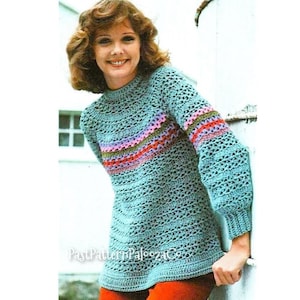 May include: A crochet top with a light blue base and a colorful striped band across the chest. The top has a round neckline and long sleeves.