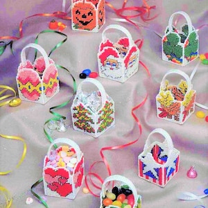 May include: Nine colorful plastic canvas bags with different holiday themes. The bags are filled with candy and are decorated with various designs, including a pumpkin, Santa Claus, a Christmas tree, a heart, a sunflower, and a patriotic design.