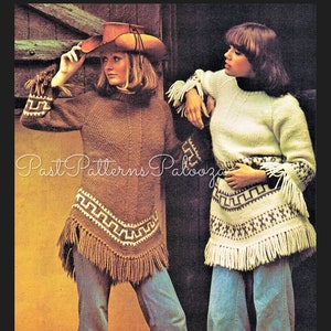 May include: Two women wearing knitted sweaters with fringe trim. The sweater on the left is brown with a geometric pattern and the sweater on the right is white with a brown geometric pattern. Both women are wearing blue jeans.