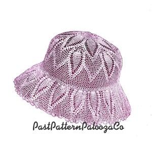 May include: A crocheted hat in a light pink color with a delicate lace pattern. The hat has a wide brim and a rounded crown.
