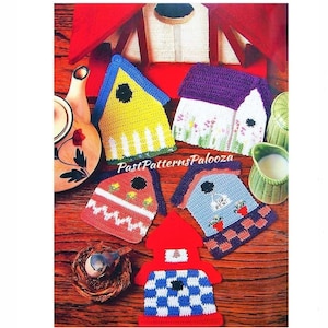 Puede incluir: Cinco posavasos de ganchillo con forma de casita de pájaros en varios colores y diseños. Los posavasos están dispuestos sobre una superficie de madera con una tetera, una jarra de leche y un nido de pájaro.