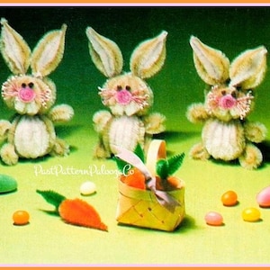 May include: Three handmade Easter bunny figures with tan fur, pink noses, and large ears. A small basket with carrots and green leaves sits near the bunnies, along with colorful jelly beans and a felt carrot. The text "Past Pattern Palooza Co" is visible.