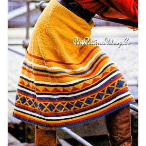 May include: A mustard yellow knit skirt featuring horizontal stripes in white, navy blue, and red, with a geometric pattern of triangles and diamonds near the hem. The text Past Pattern Palooza Co is visible on the skirt fabric.