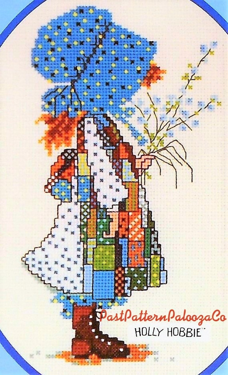 May include: Cross stitch pattern featuring a girl in a blue dress with a patchwork design, holding a bouquet of flowers. The pattern is titled "Holly Hobbie" and is from PastPatternPaloozaCo.