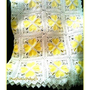 May include: A handmade, crocheted blanket featuring a repeating pattern of yellow hearts on a white background. The blanket has a scalloped edge and the text "Past Pattern Palooza D" is visible at the bottom. The blanket is likely made of cotton or a similar yarn.