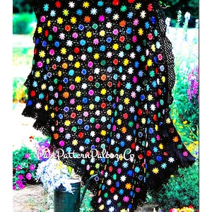 May include: A black crochet blanket with a colourful star pattern. The blanket is draped over a wooden railing and has a crocheted border.
