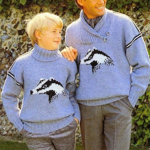 Puede incluir: Dos personas con suéteres de punto azul con un diseño de tejón. Los suéteres tienen ribetes blancos en las mangas y los cuellos. La persona de la izquierda es un niño y la persona de la derecha es un adulto.