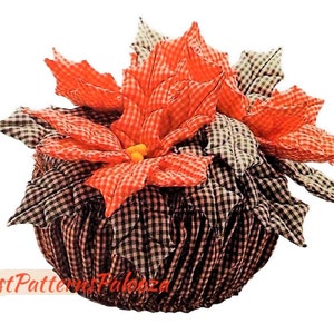 May include: A red and white gingham poinsettia flower arrangement in a black and white gingham pot. The arrangement is a handmade craft item.