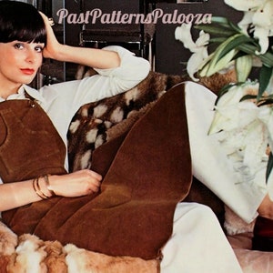 Pode incluir: Uma mulher vestindo um vestido de macacão de camurça marrom com uma blusa branca. Ela está sentada em um cobertor de pele com lírios brancos no fundo. O texto "Past Patterns Palooza" é visível na imagem.