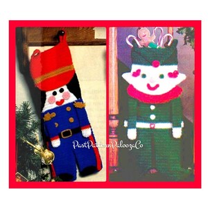 May include: Two crocheted Christmas stocking ornaments. One is a green elf with a pink face and the other is a blue and red nutcracker. Both are wearing a white belt and have a white heart on their chest.