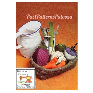 Könnte beinhalten: Ein Vintage-Nähmuster für ein Set aus Stoffgemüse, darunter eine lila Aubergine, eine grüne Paprika, ein weißer Blumenkohl, zwei orange Karotten und ein Lauch. Das Gemüse befindet sich in einem braunen Weidenkorb. Das Muster ist mit "This Is A... Digital Vintage Sewing Pattern" beschriftet.