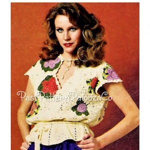 May include: A crocheted top with a V-neck and short sleeves. The top is white with a floral design in shades of pink, red, green, and purple. The top has a tie at the waist.