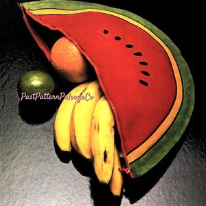 Può includere: Una pochette con cerniera a forma di anguria, rossa con dettagli di semi neri, buccia verde e bordatura gialla, contiene un'arancia matura e un mazzo di banane. Un lime verde è accanto alla pochette. Il testo "PastPatternPaloozaCo".