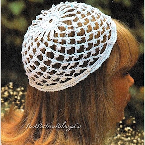 May include: A white crocheted hat with a net-like design, adorned with small beads. The hat is worn on a person's head, with long, light brown hair visible. The text "Past Pattern Palooza Co" is at the bottom of the image.