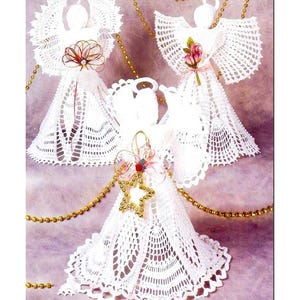 May include: Three white crocheted angel ornaments with delicate lace details. Each angel has a different floral embellishment and is adorned with gold beads and a star.
