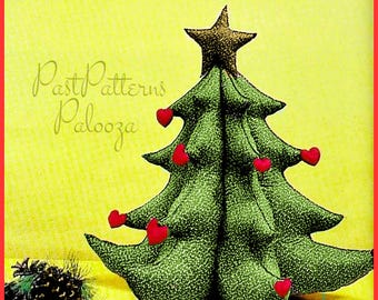Könnte beinhalten: Ein handgefertigter Weihnachtsbaum aus grünem Stoff mit roten herzförmigen Verzierungen. Der Baum wird von einem goldenen Stern gekrönt. Der Hintergrund ist gelb mit dem Text "Past Patterns Palooza".