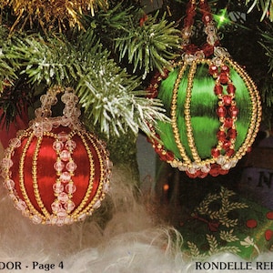 May include: Four beaded Christmas ornaments, each with a different color scheme. The ornaments are red and green, red and gold, green and gold, and white and pink. The ornaments are hanging from a Christmas tree.