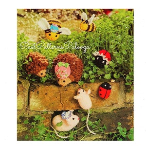 May include: Knitted animal figurines, including a bee, a ladybug, a hedgehog, and a mouse. The figurines are all wearing hats and are posed in a garden setting. The text "Past Patterns Palooza" is visible in the image.