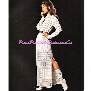 Peut inclure: Une robe en crochet blanche avec une longue jupe et une fente sur le côté. La robe a un col montant et des manches longues. Le mannequin porte des bottes blanches.
