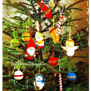 May include: A Christmas tree decorated with knitted ornaments, including a snowman, a gnome, an angel, a stocking, a candy cane, and several colorful balls. The text "Past Pattern PaloozaCo" is visible on the tree.
