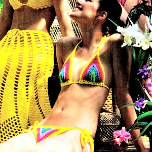 May include: A woman wearing a rainbow crochet bikini top and matching bottom. The bikini is made with a variety of colors, including yellow, orange, red, green, blue, and purple. The woman is sitting on a wicker chair with tropical plants in the background.