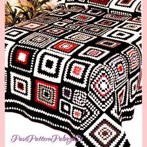 Könnte beinhalten: Eine schwarze und weiße Häkeldecke mit roten und grauen Akzenten. Die Decke besteht aus Quadraten mit verschiedenen Mustern. Die Decke liegt auf einem Bett mit einem Kissen.