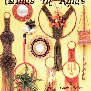 May include: A vintage book cover with the title "Macrame Things In Rings" by Corinne Nelson. The cover features a variety of macrame wall hangings, including a plant hanger, a mirror, and a bell hanger.