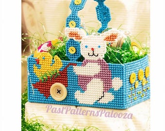 May include: A blue plastic canvas basket featuring a white bunny, a yellow duck in a red wheelbarrow, and yellow button accents. The handle is decorated with yellow buttons. The text PastPatternsPalooza is printed across the front base.